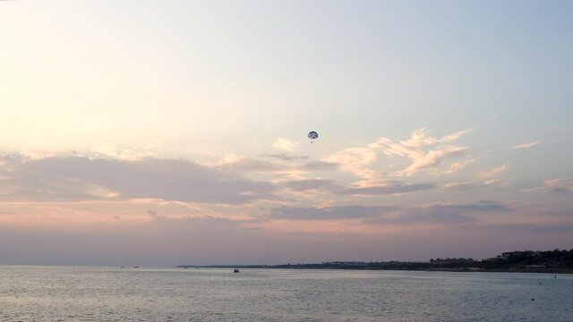 Peaceful sunset evening 4k video landscape of scenic sea in Turkey, white, pin kand blue cloudy sky after sun dawn, coast line on horizon, tourists having fun on water