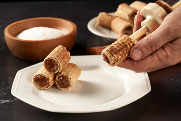 hand stuffing cubanitos with dulce de leche. cuchufli