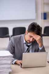 Young businessman employee and too much work in the office