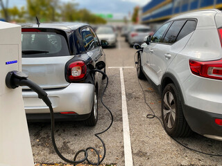 Electric vehicles plugged into a charging column.