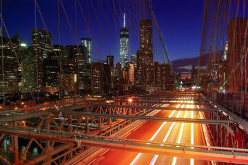 Fototapeta na wymiar Brooklyn Bridge in New York (USA) during night with view of Manhattan and car's lights 