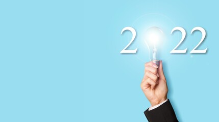 Idea and creative in 2022 text, lighting bulb with new year number on blue background
