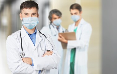 Confident nurse in front of medical team looking at camera wearing a face mask during a covid-19