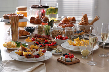 Variety of snacks on wooden table in buffet style indoors