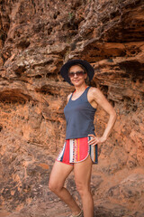 Lady at Chapada da Mesas in Maranhao, Brazil, at sunset as the sun hits off the red rocks