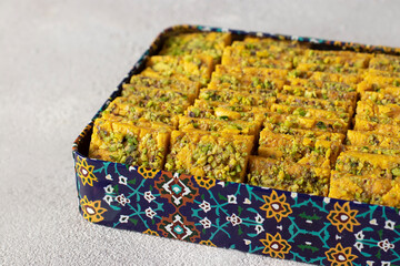 Traditional Persian dessert Sohan from Iran in box on gray background.