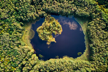 A view from a great height to a beautiful lake in the middle of a green forest, a lake on the site of the former peat mining