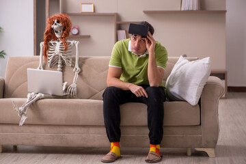 Young man with female skeleton in virtual reality concept