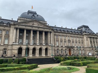 Obraz premium Front facade of The Royal Palace of Brussels. It is is the official palace of the Belgian Royal family (King and Queen) in the city centre. Belgian flag on top of the building. Bruxelles, Belgium