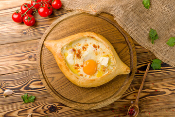 ajara Khachapuri with cheese, egg and butter, georgian kitchen on wooden table top view