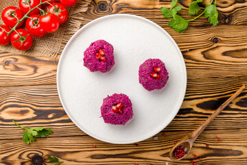 pkhali from beet Georgian cuisine on white plate on wooden table top view