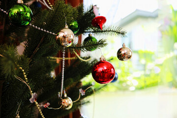 Closeup of red bauble hanging from a decorated Christmas tree, beautiful decorative Christmast tree, New year party concept