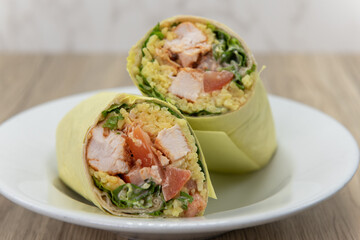 Loaded Tikka chicken wrap cut in half to show cross section of rice and ingredients