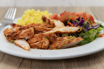 Complete grilled tikka chicken meal sliced up with rice and salad for a hearty appetite