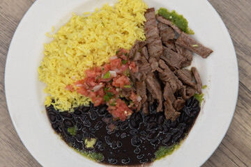 Overhead view of complete grilled tikka steak meal sliced up with rice and salad for a hearty appetite