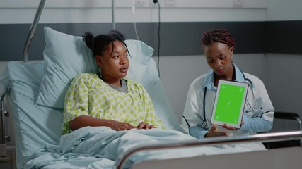Doctor and patient using digital device with green screen in hospital ward. Specialist and young woman looking at mockup template and isolated background with chroma key on tablet. - Powered by Adobe