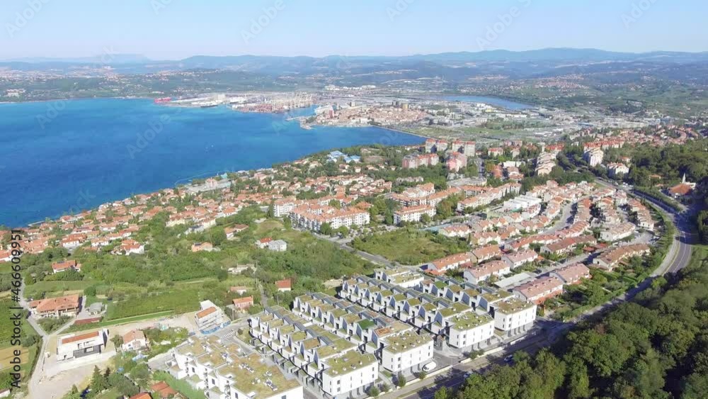 Sticker a scenic drone shot of the city buildings surrounded by trees and the sea