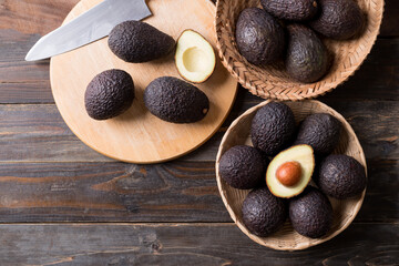 Ripe hass avocado fruit in a basket on wooden background, Healthy eating, Table top view