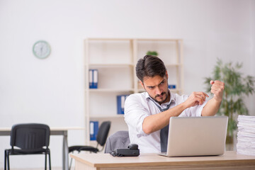 Young male employee and too much work in the office