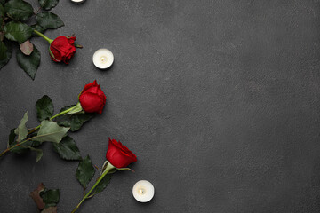 Beautiful red roses and burning candles on dark background