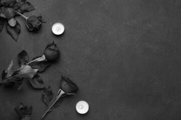 Beautiful roses and burning candles on dark background
