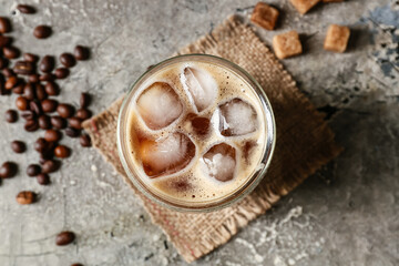 Fototapeta na wymiar Glass of tasty iced coffee on grunge background
