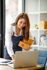 Portrait of Starting small businesses SME owners female entrepreneurs working on receipt box and check online orders to prepare to pack the boxes, sell to customers, SME business ideas online.