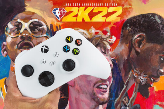 Male hand holding a Xbox Series S White Controller with Nba 2k22 game blurred in the background. Rio de Janeiro, RJ, Brazil. November 2021