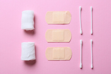 Bandage, medical plasters and cotton buds on color background