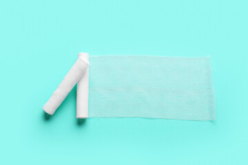 Bandage rolls on color background