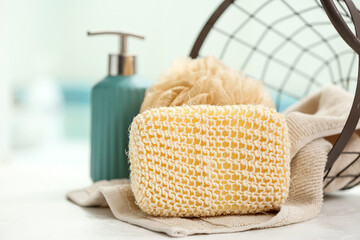 Fototapeta na wymiar Bath sponge and towel on table in bathroom, closeup