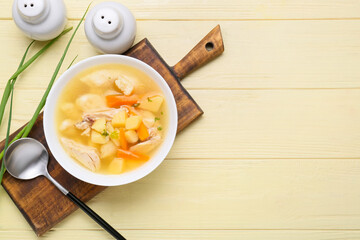 Bowl of tasty dumpling soup on color wooden background