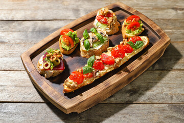 Board with different tasty vegetarian bruschettas on wooden background