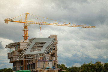 Construction site with yellow lifting crane and blue sky background.