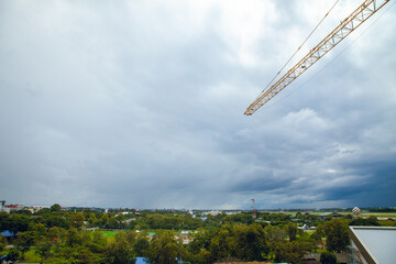Construction site with yellow lifting crane and blue sky background.
