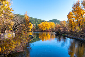 View of the Wenatchee River at autumn with fall colors on the leaves from Blackbird Island at Leavenworth, Washington, USA.