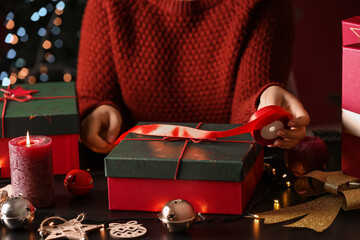 Woman decorating Christmas gift box at home, closeup