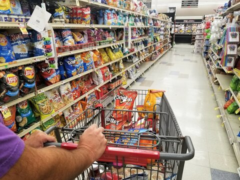 Wilmington, Delaware, U.S.A - September 7, 2021 - Pushing a cart on the snacks aisle inside a grocery shop