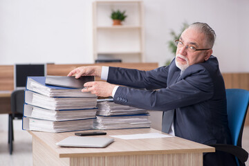 Aged male employee sitting at workplace