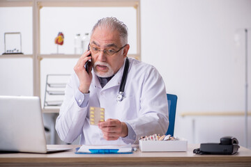 Old male doctor in telemedicine concept