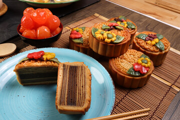 Mid autumn festive colorful flower decorated moon cake making ingredients salted egg yolk flour honey syrup yam paste oil sugar chopsticks spoon plate bowl wooden bamboo tin glass