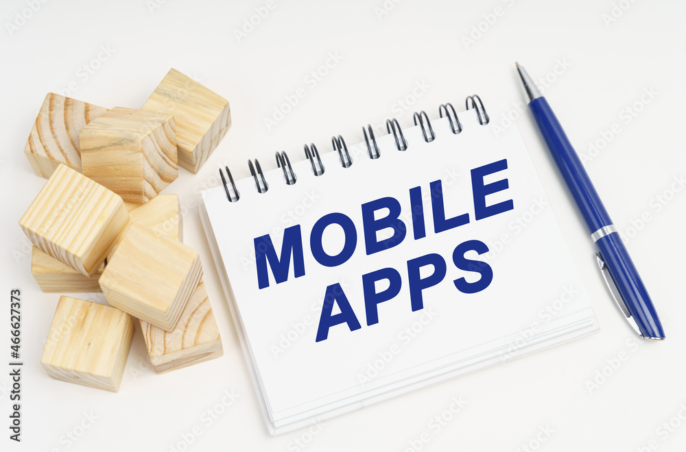 Poster On the table are cubes, a pen and a notebook with the inscription - Mobile Apps