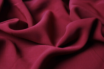 The texture of silk fabric burgundy color. Background, pattern. Luxury chiffon textile pattern....
