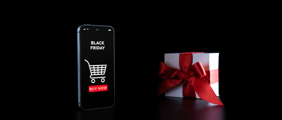 Season sale. Internet online shopping app on mobile phone, white gift box with red ribbon isolated on black background in Black Friday background. Shopping gift concept.