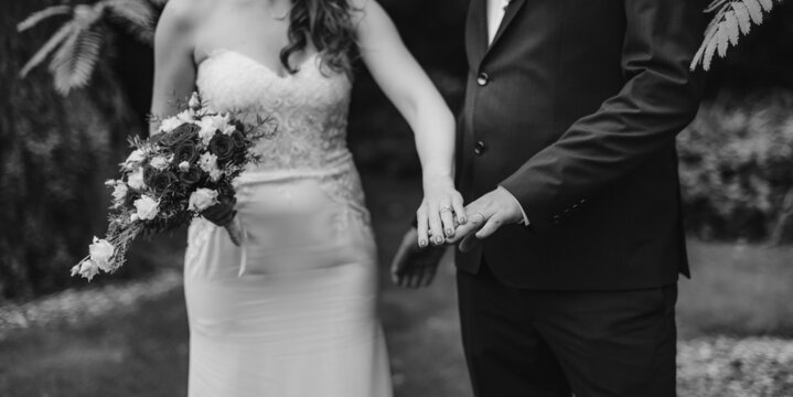 Black and white photo of bride and groom with wedding ring.