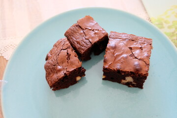 Slices of homemade brownie, selective focus.  Pieces of brownies on wooden table. Chocolate cakes with walnuts. It is called 