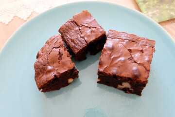 Slices of homemade brownie, selective focus.  Pieces of brownies on wooden table. Chocolate cakes with walnuts. It is called 
