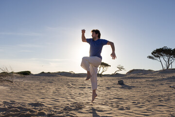 retroiluminación de un joven practicando artes marciales al atardecer