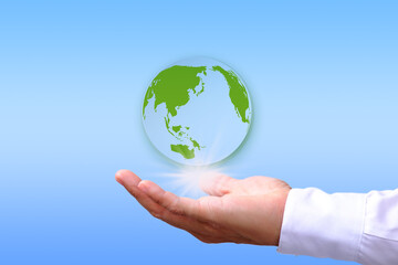 Save energy to help the environment, with a hand holding the earth on a blue background.