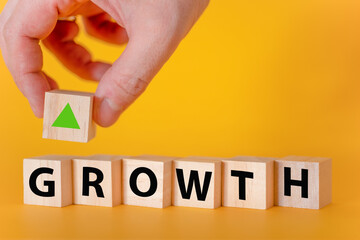 The word grow on wooden cubes on a yellow background.